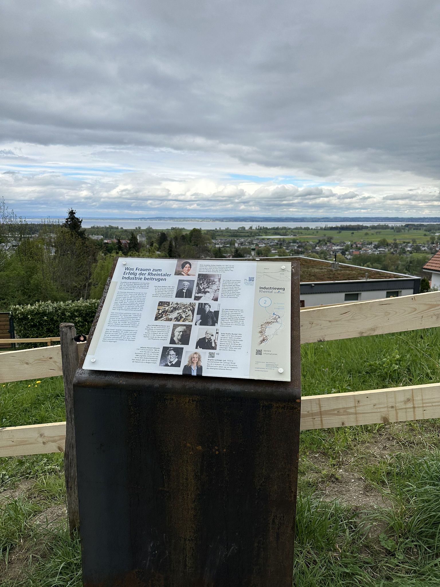 Informationstafel im Aussenbereich mit Aussicht auf Landschaft und Siedlung entlang eines Industriewegs