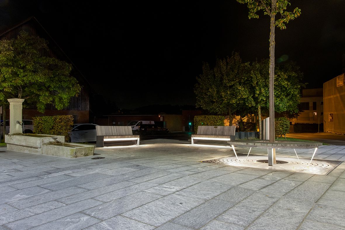 Öffentlicher Platz bei Nacht mit Sitzbänken und integrierter LED-Leitsystembeleuchtung für Orientierung und Aufenthaltsqualität