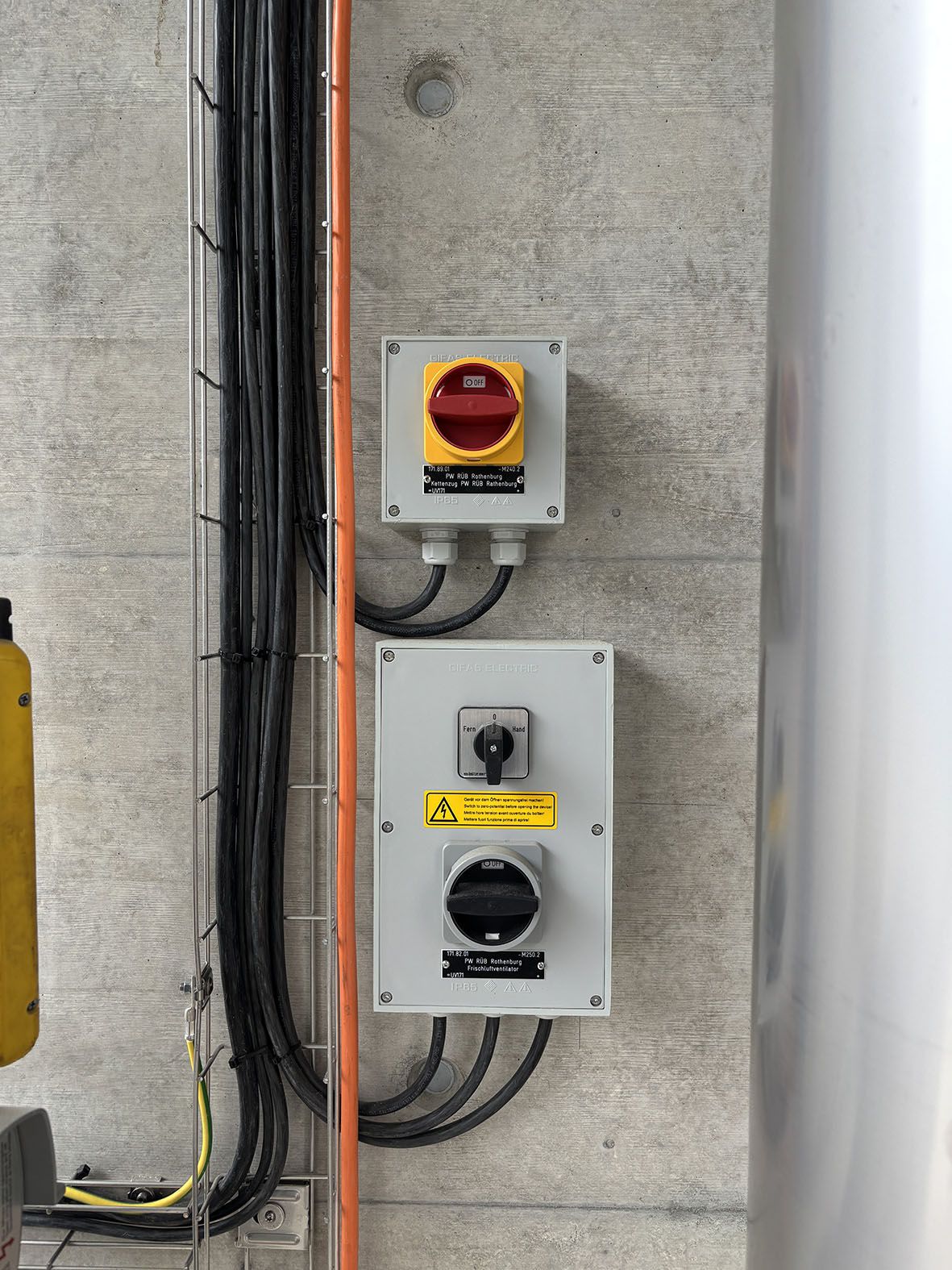 Interruttore di sicurezza su parete in calcestruzzo con cavi di collegamento - controllo sicuro e distribuzione di energia negli impianti di trattamento delle acque reflue