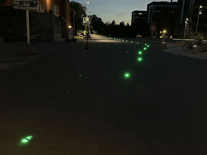 Reihe grüner TrafficLED Bodenleuchten sorgt in der Nacht für klare Orientierung für Passanten und Velofahrende