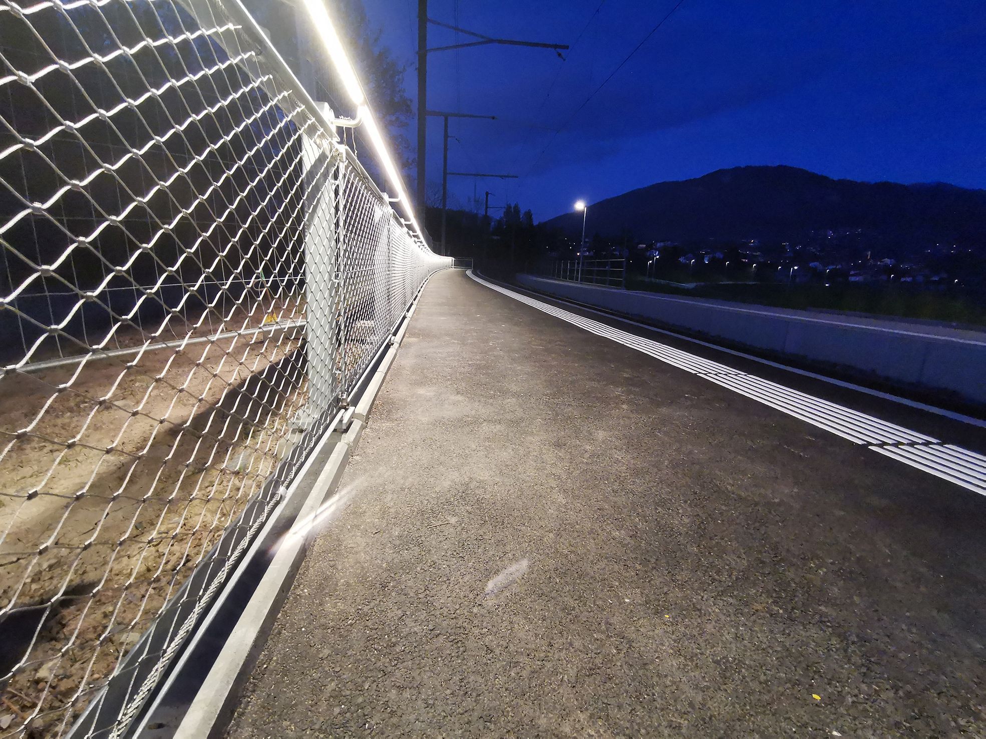 Inox42 handrail with integrated LaneLED lighting provides safe guidance along the platform at dusk