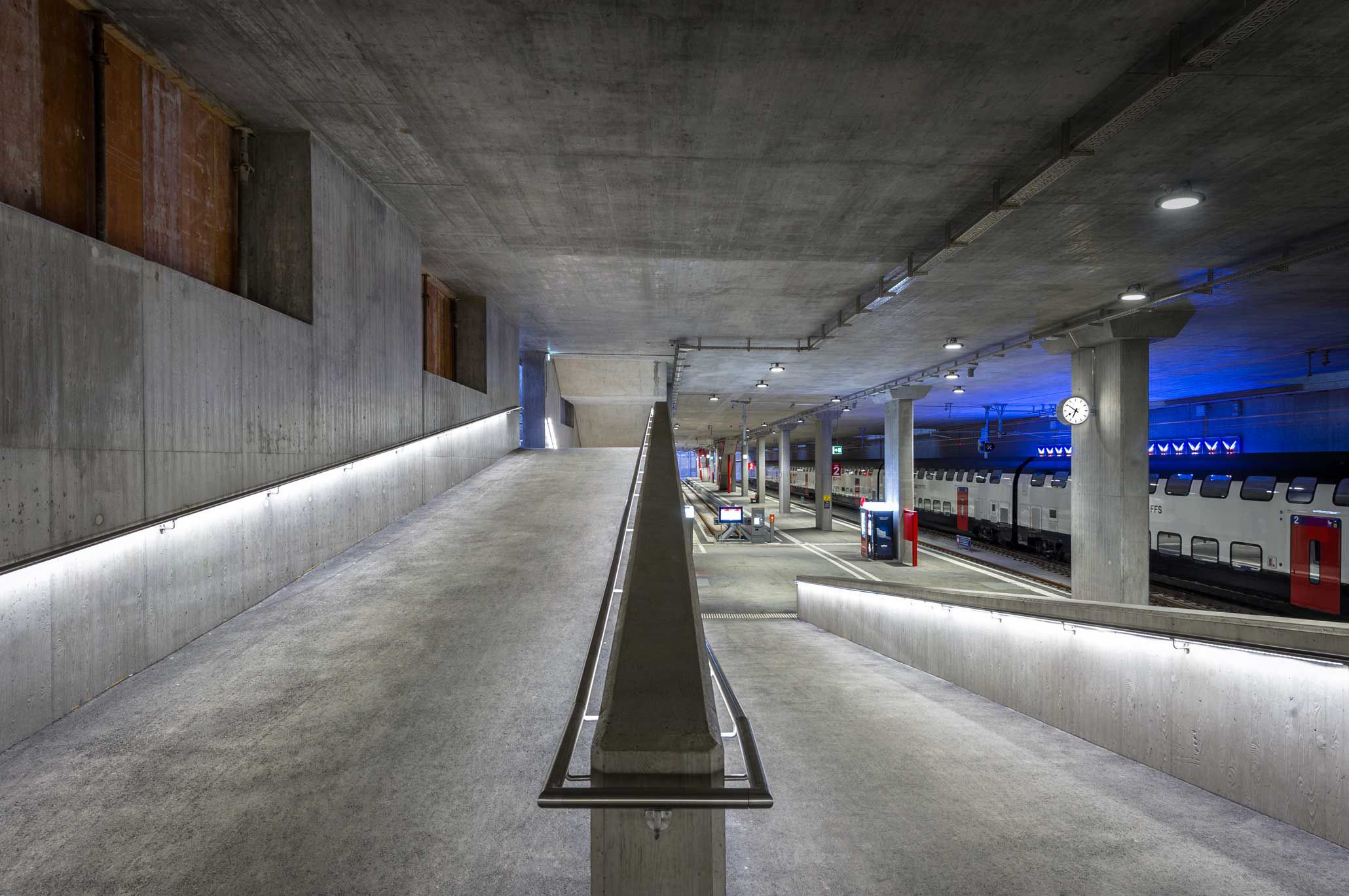 Illuminated ramp in the station with continuous LED handrail and clear routing - safe connection between platform and access level