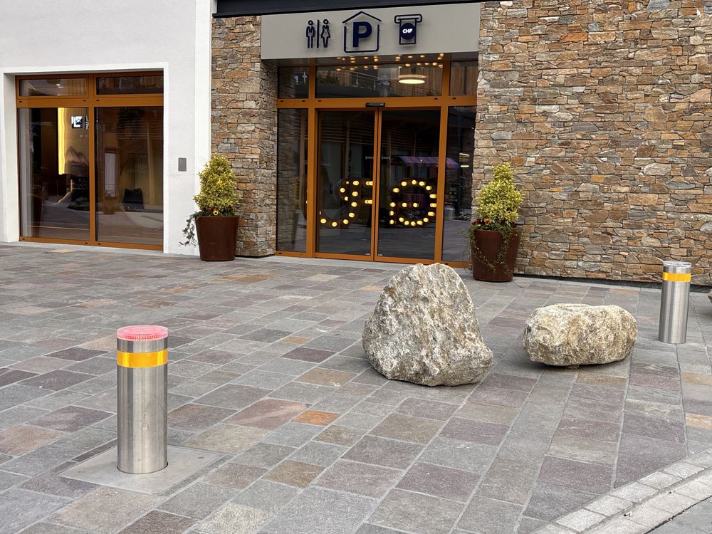 Borne escamotable avec feu de signalisation jaune pour sécuriser l'accès des véhicules à une place publique pavée