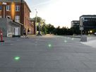 Grüne TrafficLED Bodenleuchten markieren einen grossen öffentlichen Platz und verbessern die Orientierung für Fussgänger in der Abendstimmung
