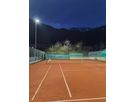 LED outdoor lighting of a tennis court with uniform illumination of the playing surface at dusk
