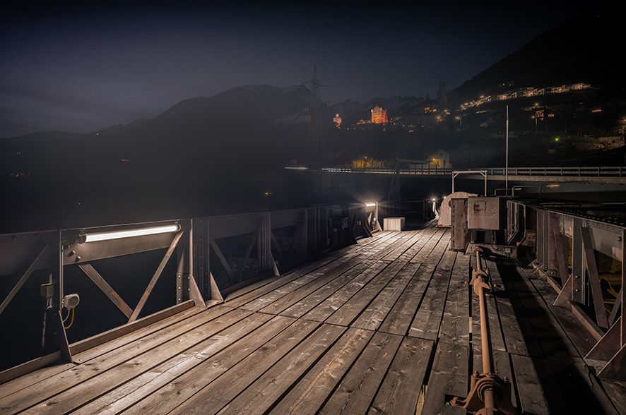 Illuminated maintenance walkway on a dam with LED lighting for safe use at night