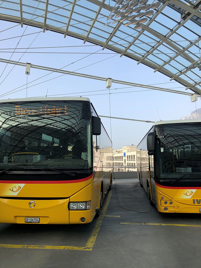 Two postbuses at the Chur post deck with connected traction cable reels for the power supply