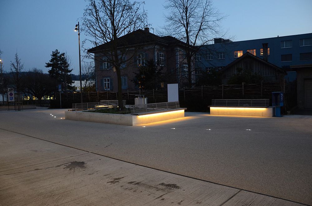 Station square with illuminated seating areas and integrated LED floor lights - safe and inviting lighting in public spaces