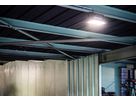 I faretti LED AlphaLUXX installati sul soffitto di un capannone industriale illuminano in modo brillante e uniforme le aree di lavoro e le strutture di lavaggio