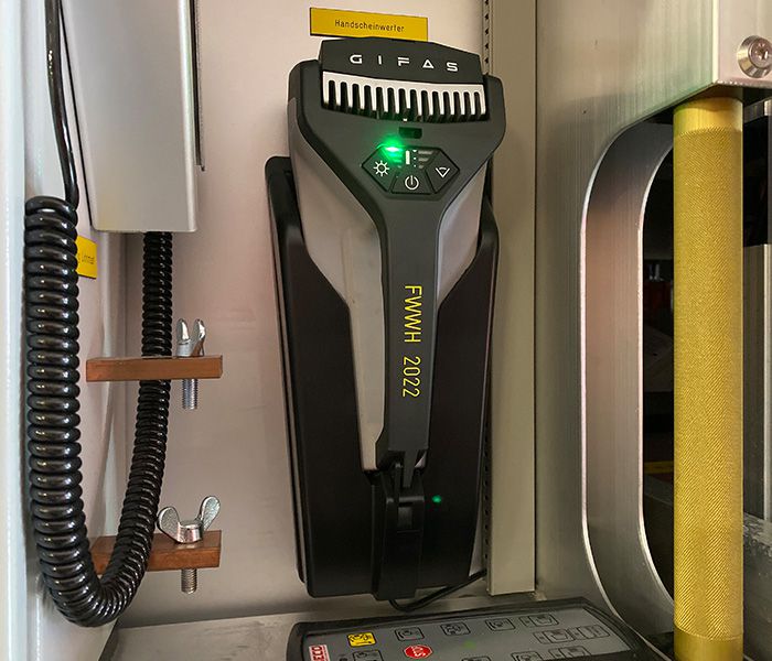 LED-Handscheinwerfer in einer Einsatzfahrzeughalterung – mobiles Arbeitslicht für Polizei und Rettungskräfte