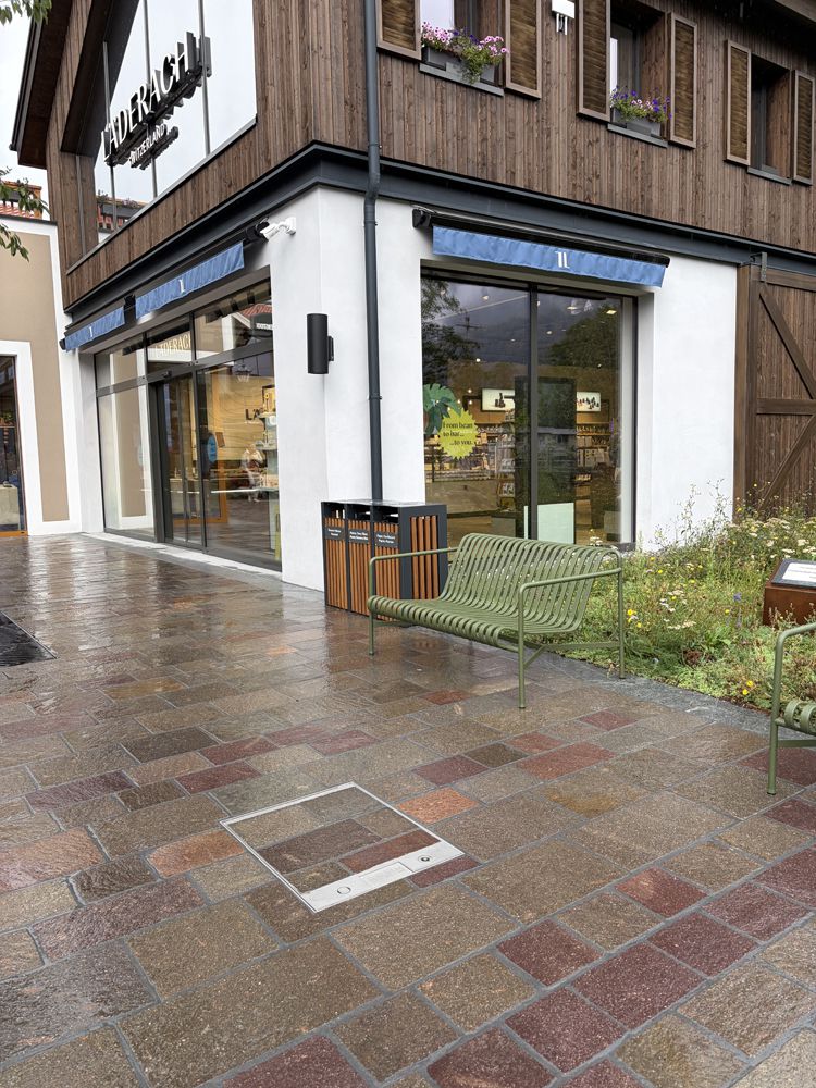 Prise de sol encastrée dans le pavage extérieur d'un bâtiment pour une alimentation électrique discrète et pratique