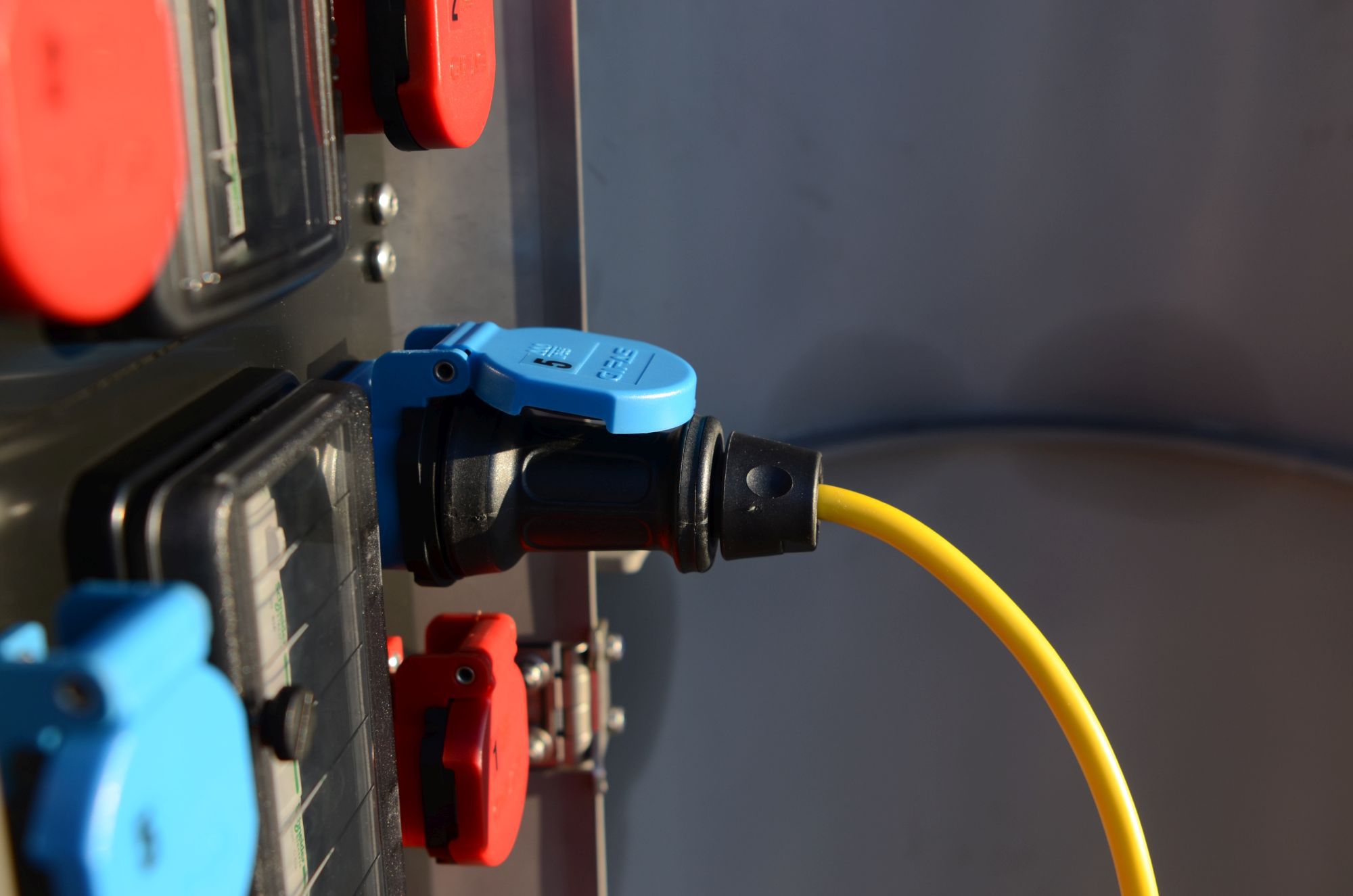CEE-Steckverbindung an Stromverteiler mit angeschlossenem Kabel für sichere Stromverteilung im Aussenbereich