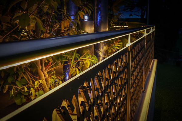 Stylish LED handrail lighting on a decorative garden railing - warm accent lighting for paths and outdoor seating areas