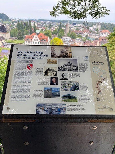 Informationstafel mit Stadtansicht im Hintergrund entlang eines Industriewegs im öffentlichen Aussenbereich