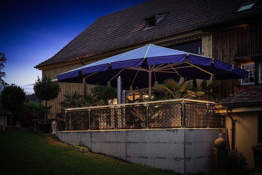 Area di seduta in giardino con ringhiera decorativa e illuminazione integrata del corrimano a LED - illuminazione d'accento d'atmosfera nell'area esterna