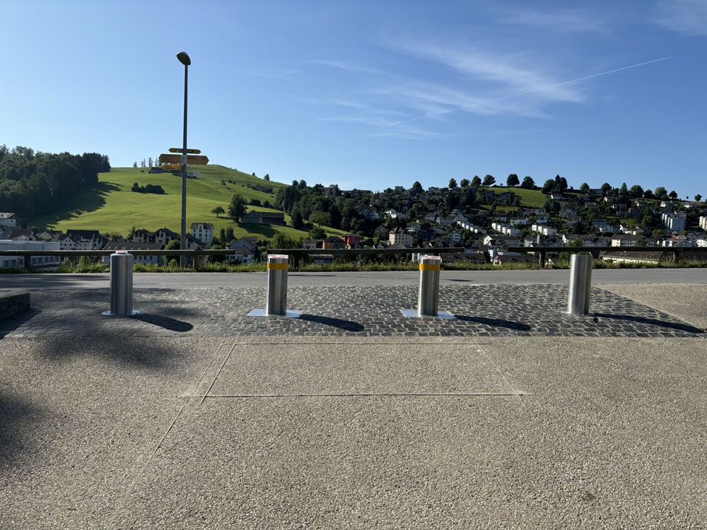 Sistema di dissuasori presso la cappella del cimitero di Herisau - dissuasori automatici in acciaio inox per un controllo sicuro degli accessi con vista sulla campagna appenzellese