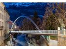 LaneLED illuminated pedestrian bridge over the Plessur in Chur provides safe guidance at dusk against an alpine backdrop