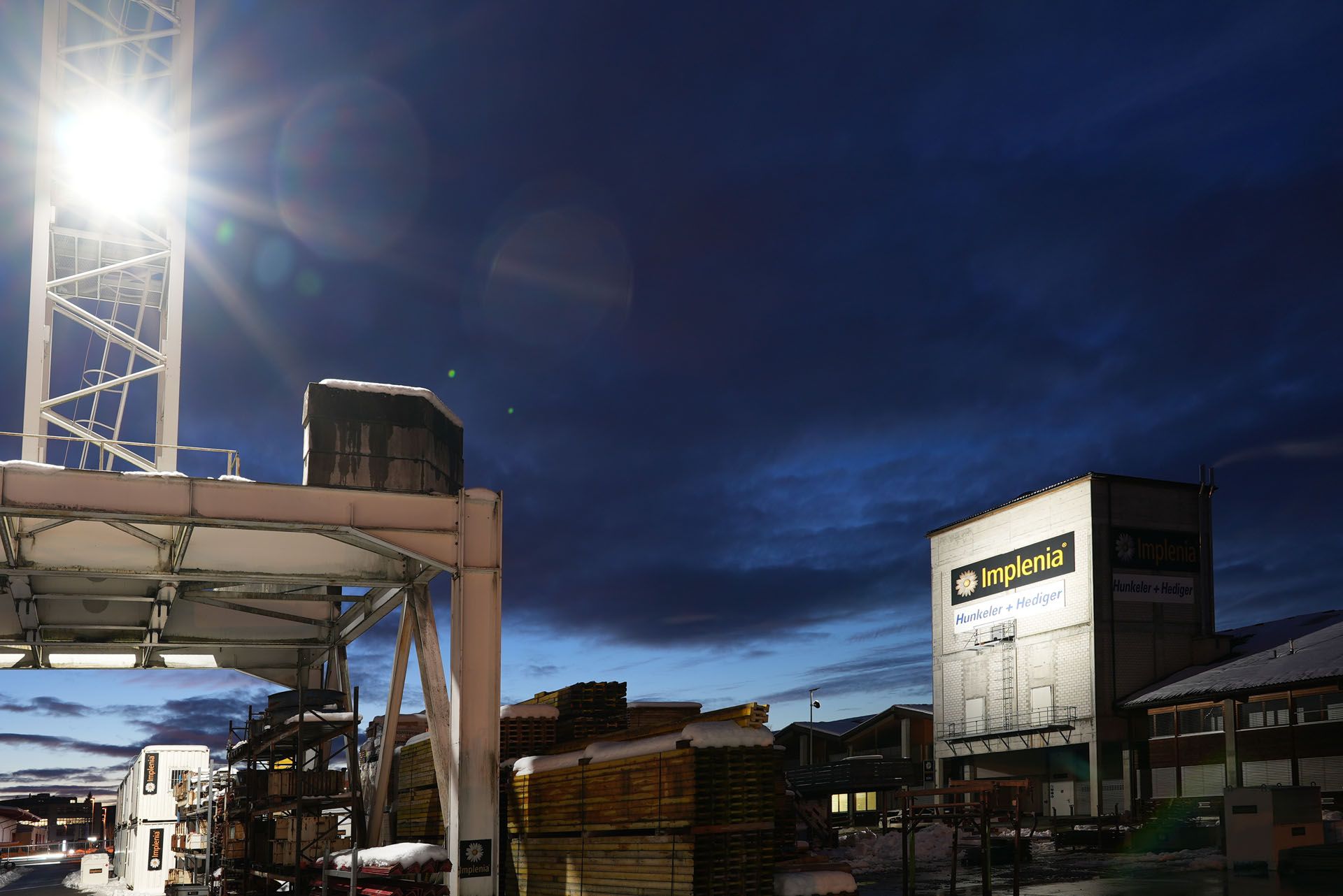 LED-Baustellenbeleuchtung an einem Baukran zur grossflächigen Ausleuchtung eines Industrieareals bei Nacht