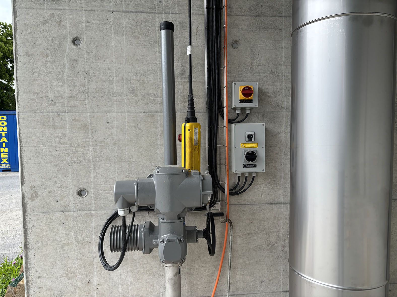 Interruttore di sicurezza e scatola di derivazione su parete in calcestruzzo - distribuzione di energia industriale con unità di azionamento collegata