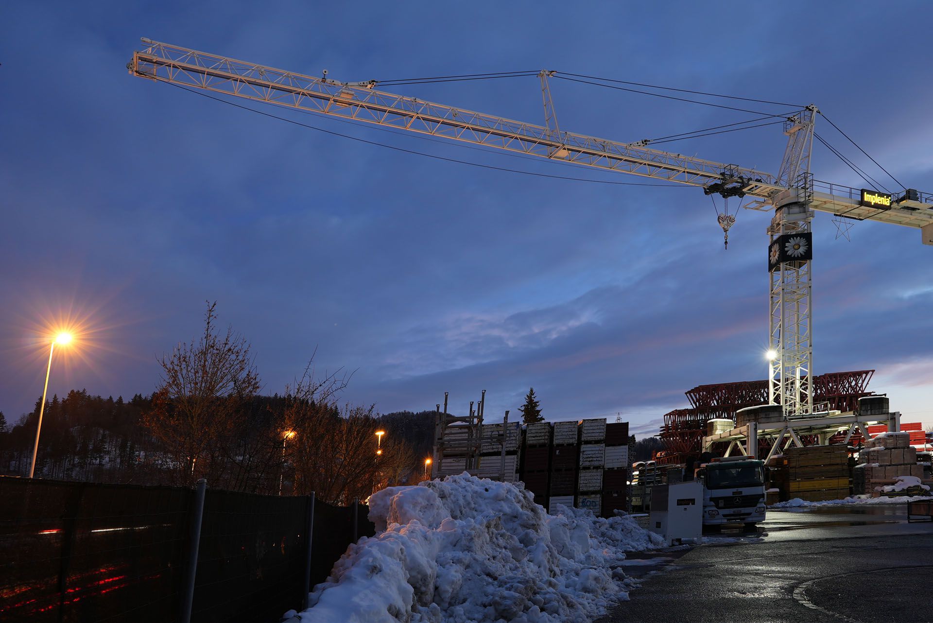 LED-Kranbeleuchtung auf einer Baustelle mit grossflächiger Ausleuchtung des Arbeitsareals in den Abendstunden