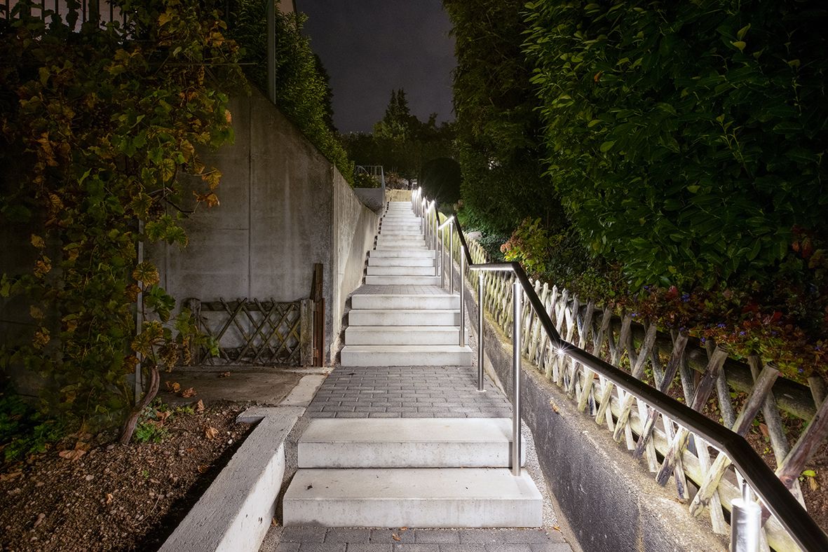 Aussen-Treppenanlage mit integrierter LED-Leitsystembeleuchtung entlang des Handlaufs für sichere Orientierung bei Nacht