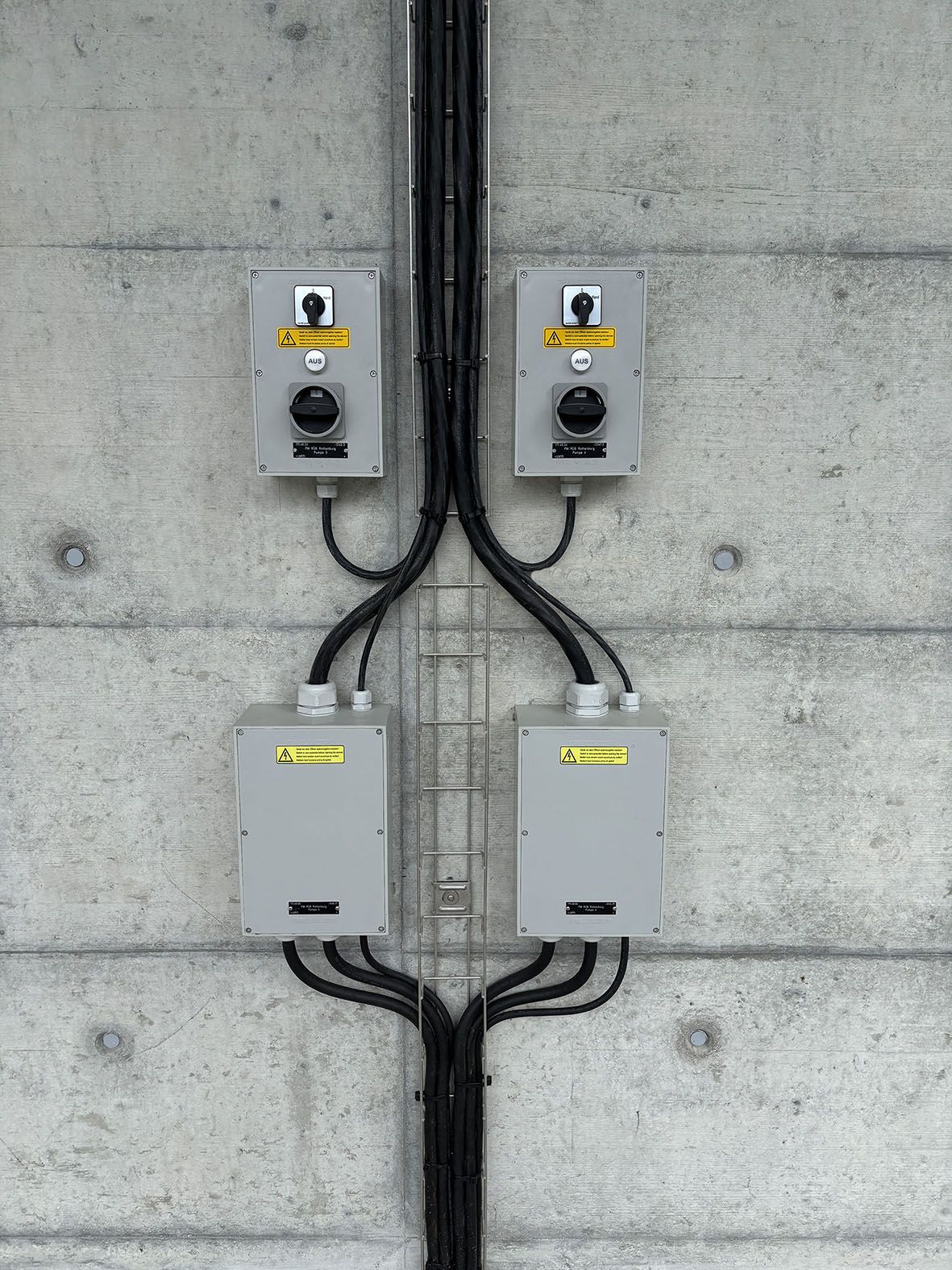 Due interruttori di sicurezza e scatole di derivazione su una parete di cemento - distribuzione sicura dell'energia per impianti industriali e infrastrutture