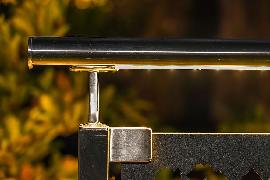 Primo piano di un corrimano in acciaio inox illuminato a LED su una ringhiera da giardino: un'elegante illuminazione d'accento per vialetti e aree salotto