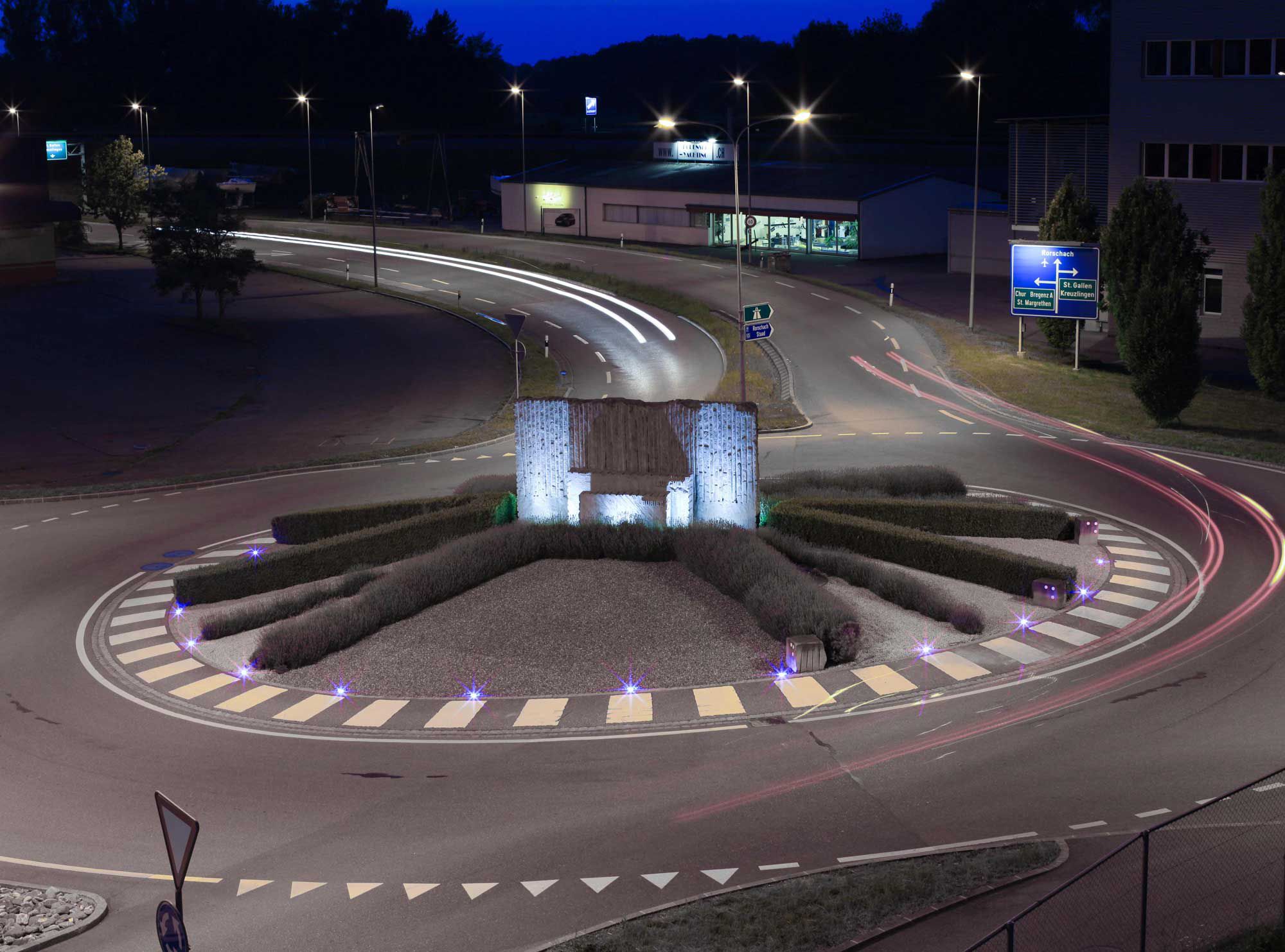 Luci di terra e illuminazione stradale a LED in una rotatoria con spartitraffico illuminato per un migliore orientamento notturno