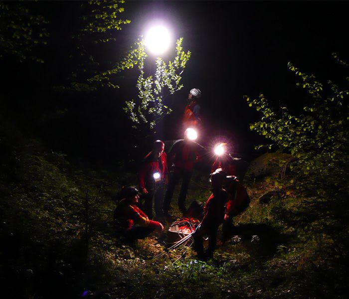 Bergrettung bei einem nächtlichen Einsatz mit mobiler LED-Beleuchtung im Gelände