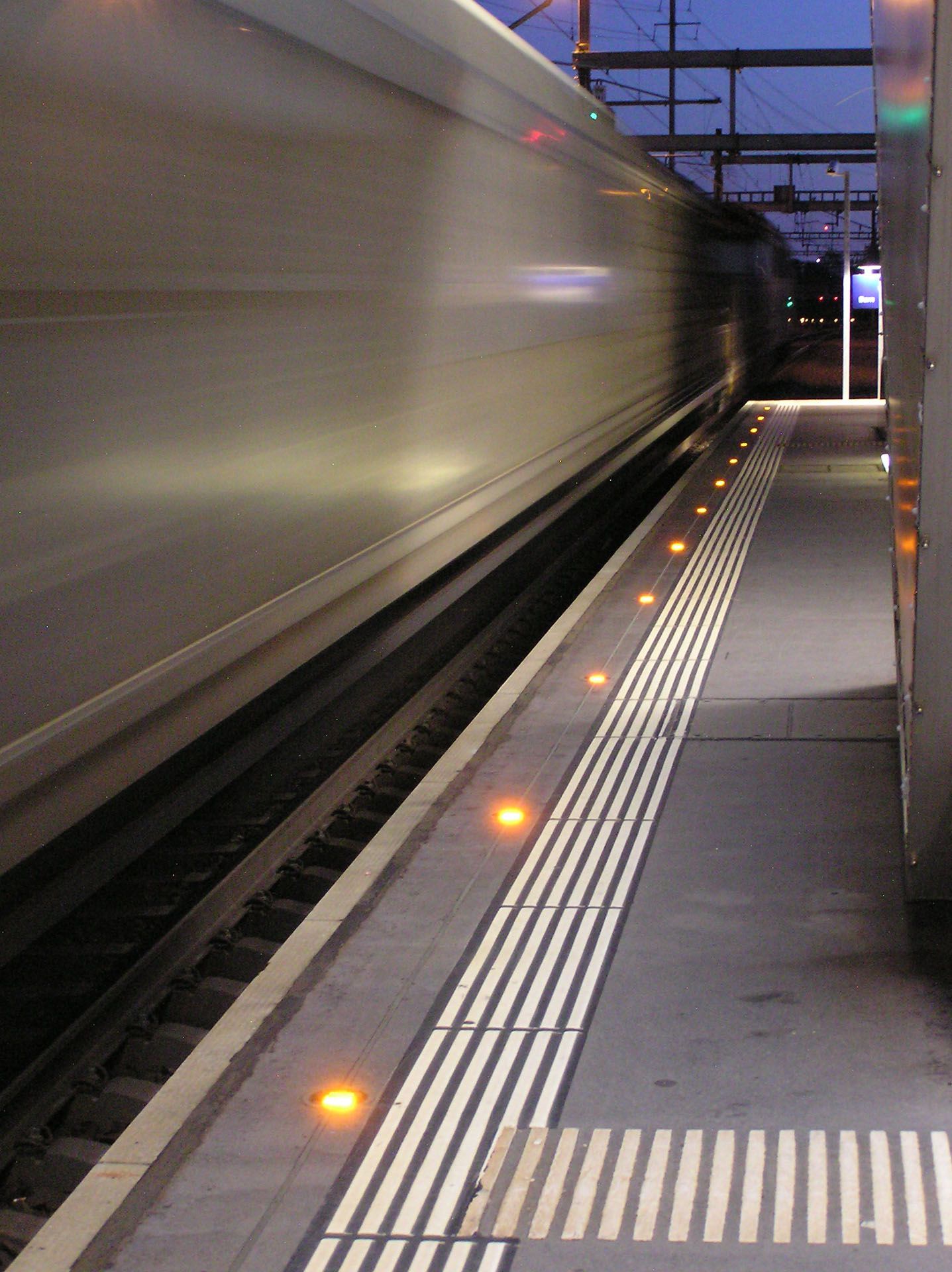 Passing train with active LED safety lighting at the platform edge at Wankdorf station