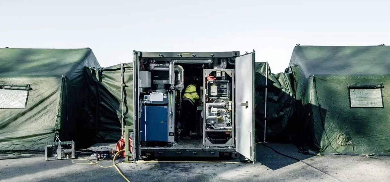 Mobiles Containersystem mit Stromverteilung und technischen Geräten im Feldeinsatz zwischen Zelten