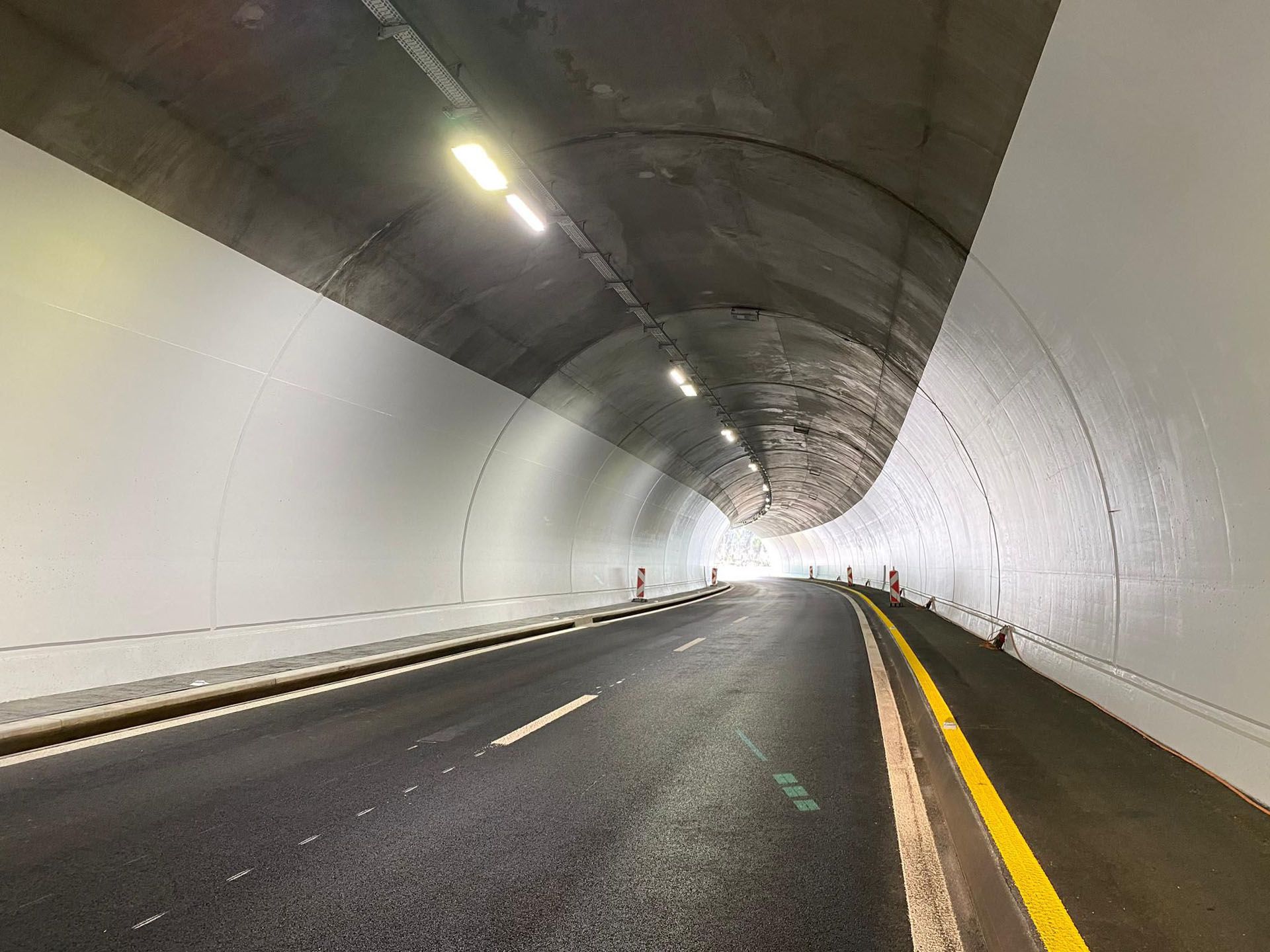 Well-lit road tunnel with LED ceiling lighting for clear visibility and safe traffic guidance along the roadway