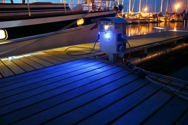 Beleuchtete GIFAS Energiesäule am Bootssteg sorgt im Hafen bei Nacht für eine zuverlässige und sichere Stromversorgung.