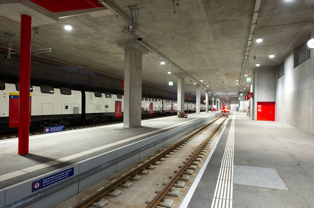 Bright station platform with LED ceiling lighting, track system and waiting train - safe and well-lit infrastructure in the basement