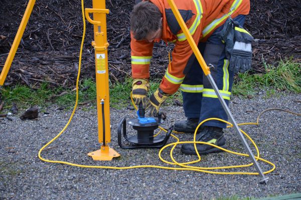 Firefighter connects hard rubber cable reel with work light for power supply in use