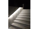 Illuminated handrail with integrated LED light line on a concrete staircase at Glis cemetery