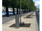 Closed GIFAS power supply bollard installed along a tree-lined waterfront promenade with benches for discreet outdoor power distribution