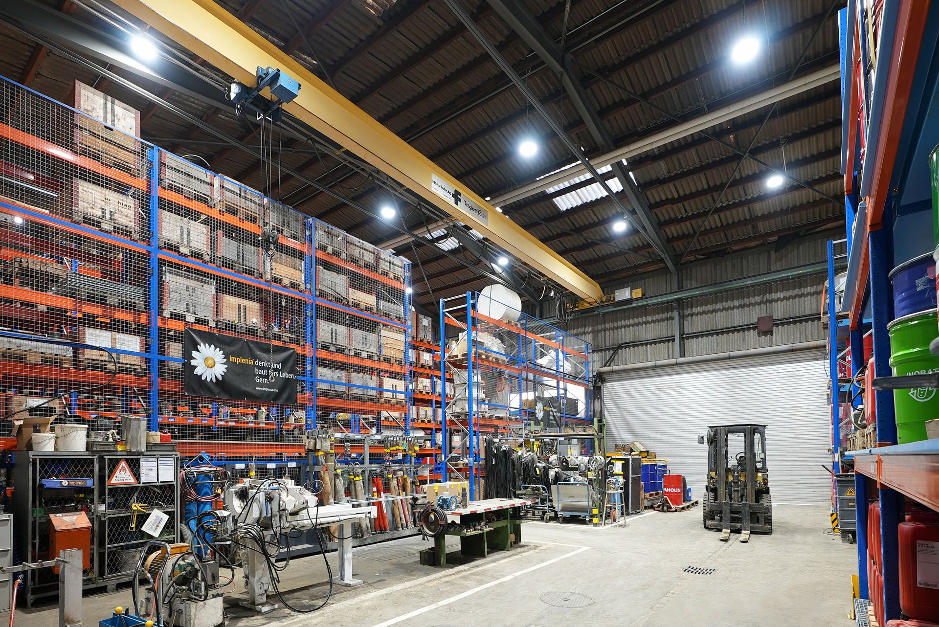 Illuminazione a LED in un capannone industriale con soffitto alto per un'illuminazione uniforme delle aree di stoccaggio e produzione