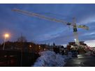 LED-Kranbeleuchtung auf einer winterlichen Baustelle mit grossflächiger Ausleuchtung des Arbeitsareals bei Dämmerung