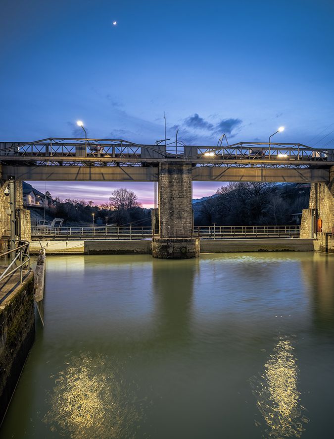 Dam with bridge construction and integrated LED infrastructure lighting for safe illumination at twilight