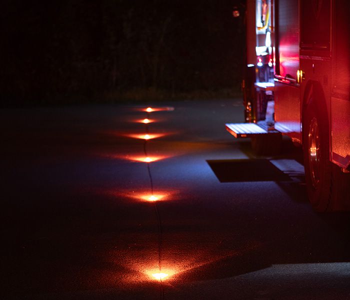 Warnleuchten auf der Strasse zur Absicherung eines Feuerwehreinsatzes bei Nacht