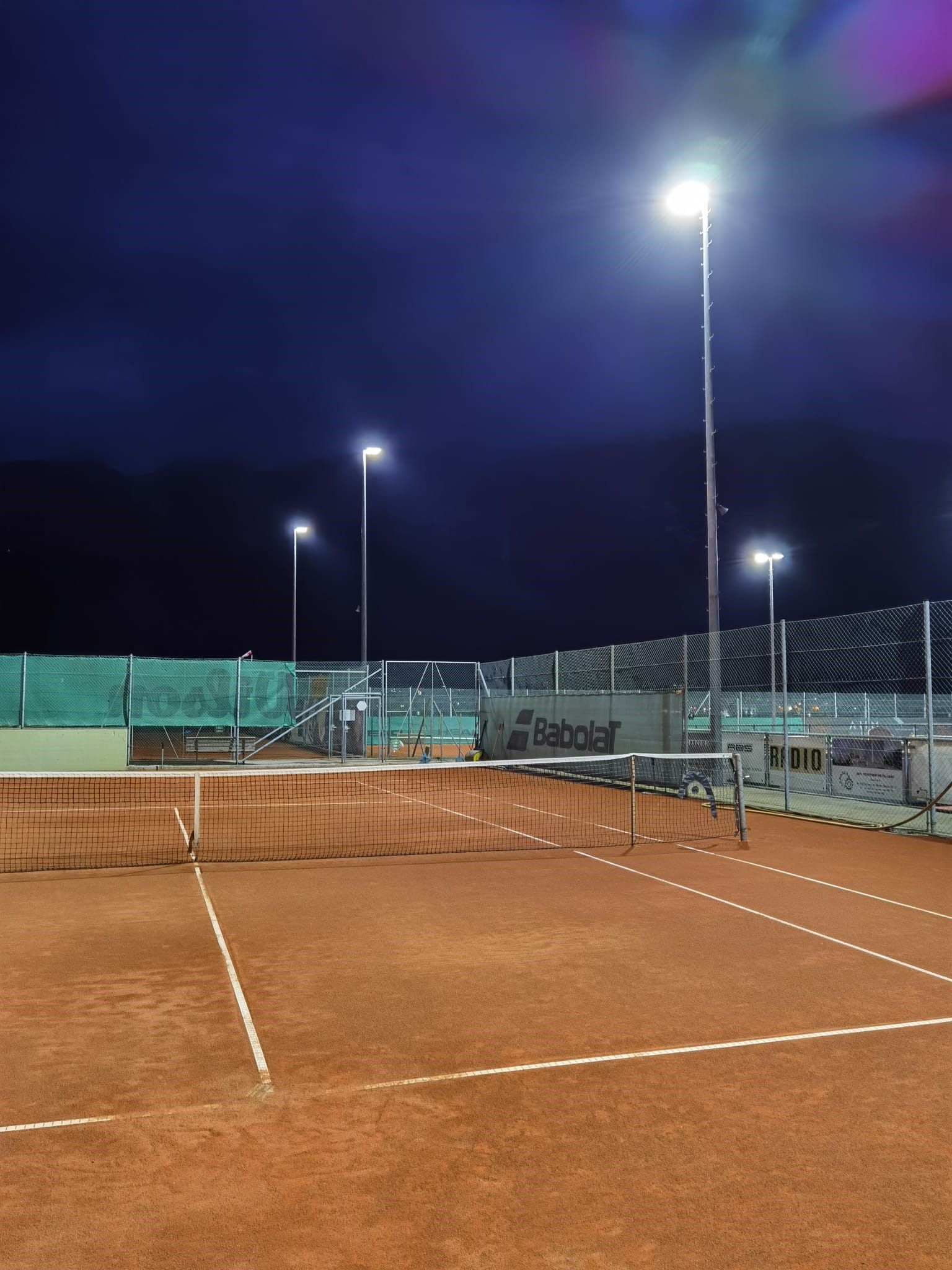 LED floodlight system on a tennis court with uniform illumination of the playing surface at night
