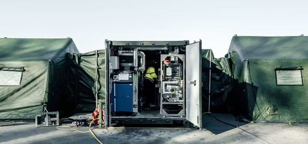 Mobiles Containersystem mit Stromverteilung und technischen Geräten im Feldeinsatz zwischen Zelten