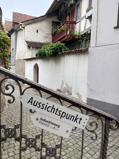 Wegweiser zum Aussichtspunkt entlang eines Industriewegs in einer historischen Ortsumgebung