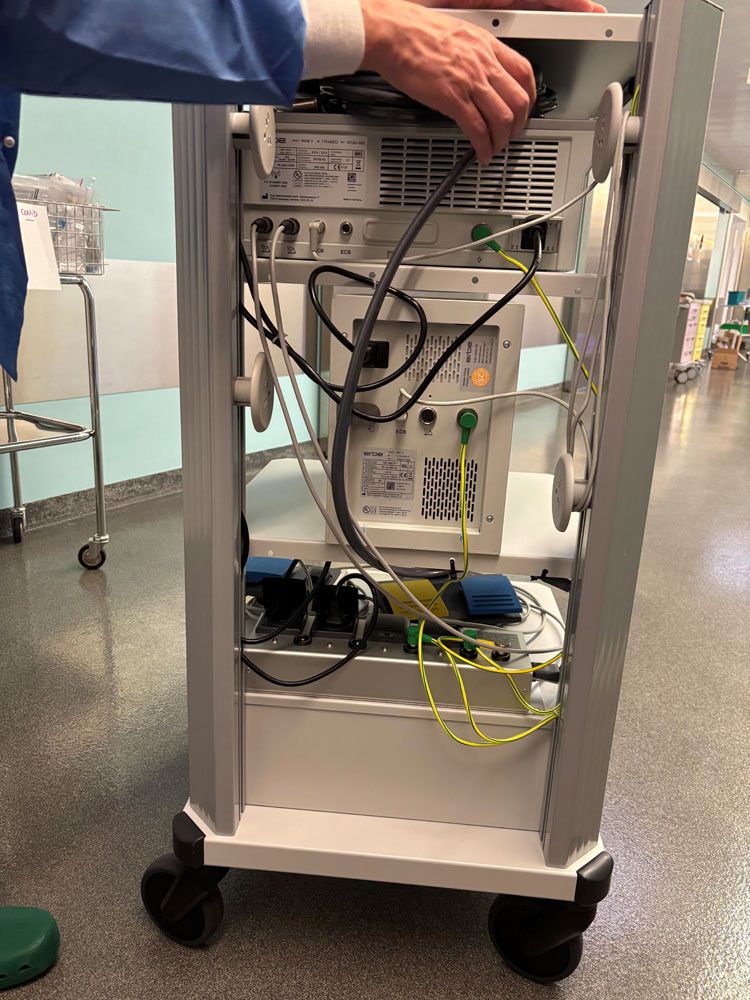 Chariot d'équipement médical avec distribution de courant et câbles connectés dans un couloir d'hôpital - alimentation électrique sûre dans le secteur de la santé