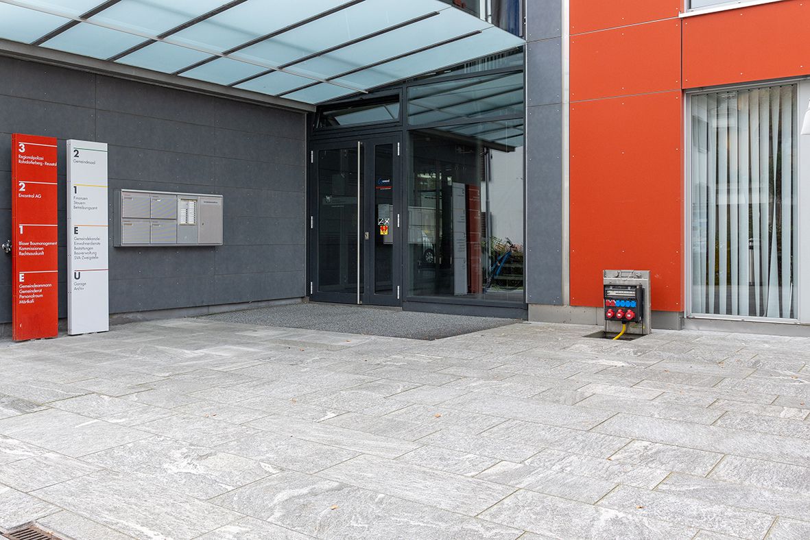 Energiesäule aus Edelstahl im Aussenbereich eines Gebäudes für sichere Stromversorgung öffentlicher Flächen