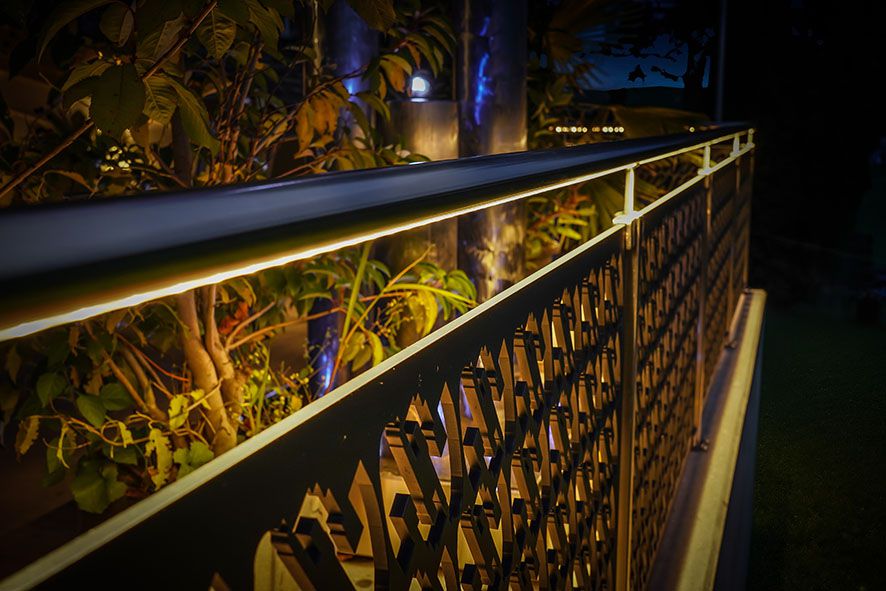 Elegante illuminazione a LED per corrimano su una ringhiera decorativa da giardino - calda illuminazione d'accento per sentieri e aree di seduta all'aperto