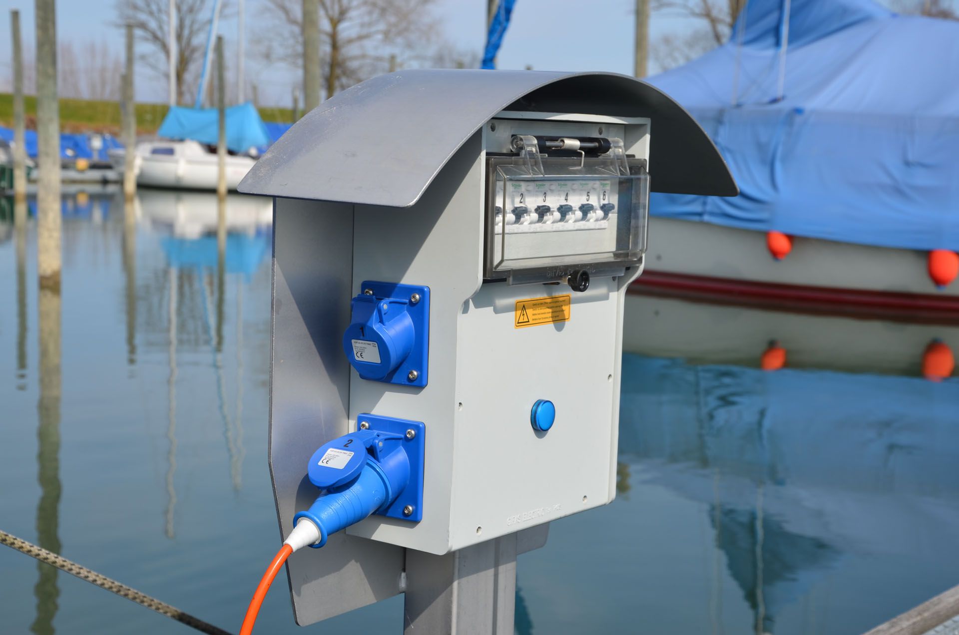 Power column in the harbor for supplying power to boats - robust power distribution for shipping