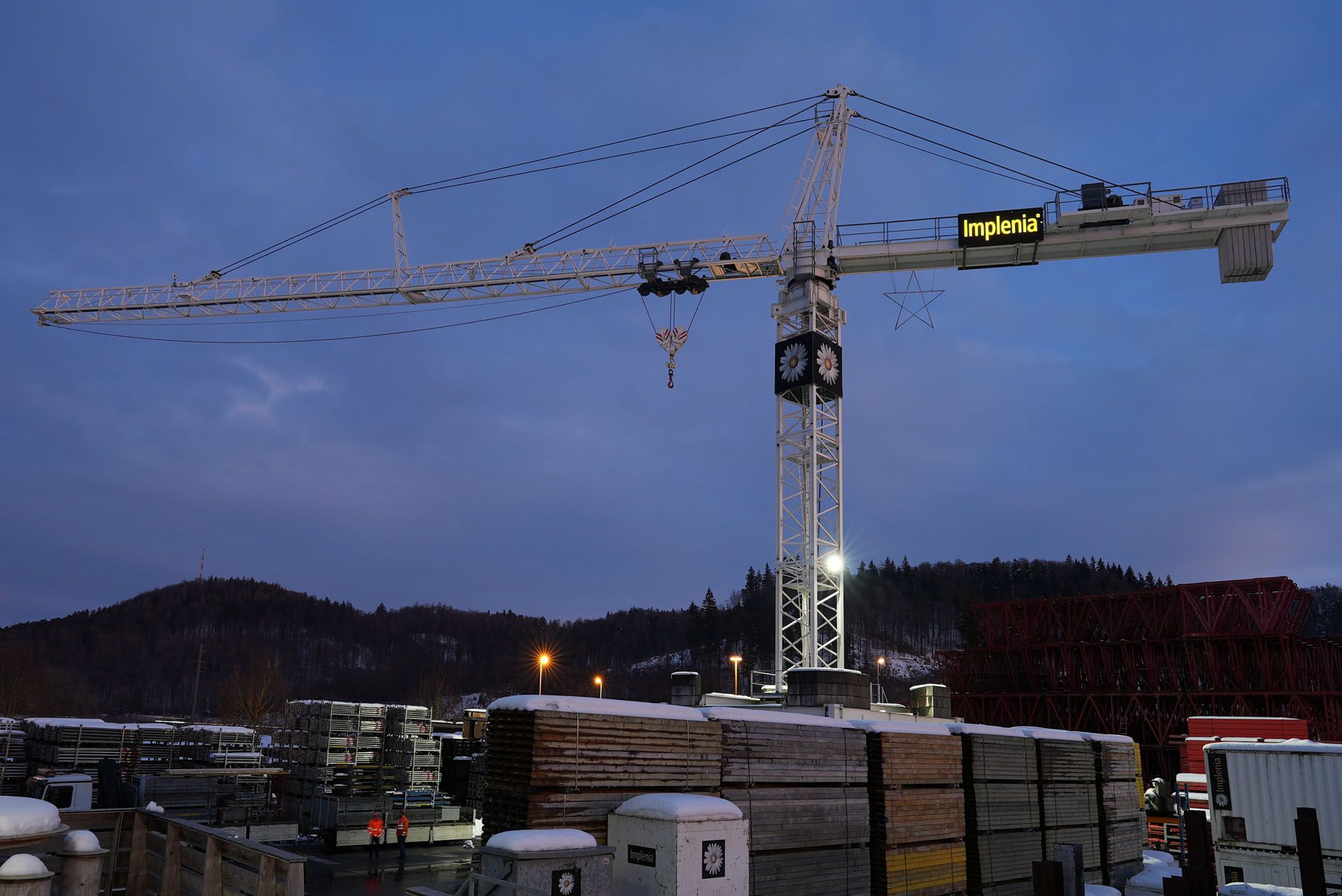 LED-Kranbeleuchtung auf einer Baustelle mit grossflächiger Ausleuchtung des Arbeitsareals bei Dämmerung