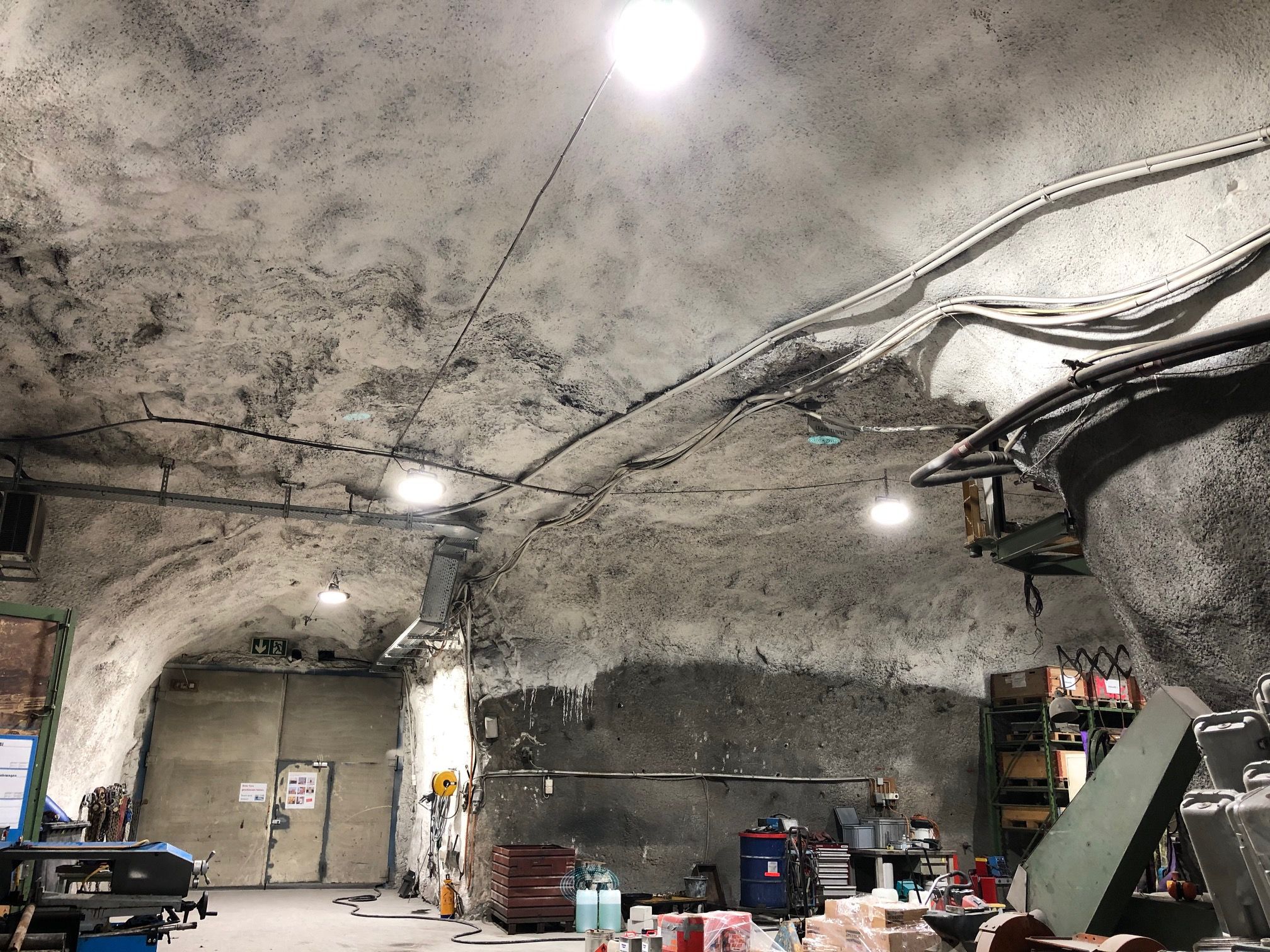 Test gallery with bright LED ceiling spotlights, workshop equipment and visible rock structure - reliably illuminated work zone